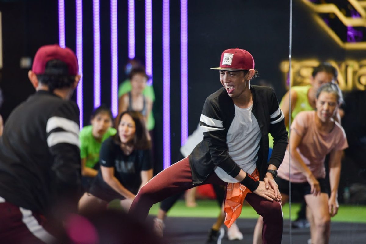 Instructor leading an energetic dance class in front of the mirror