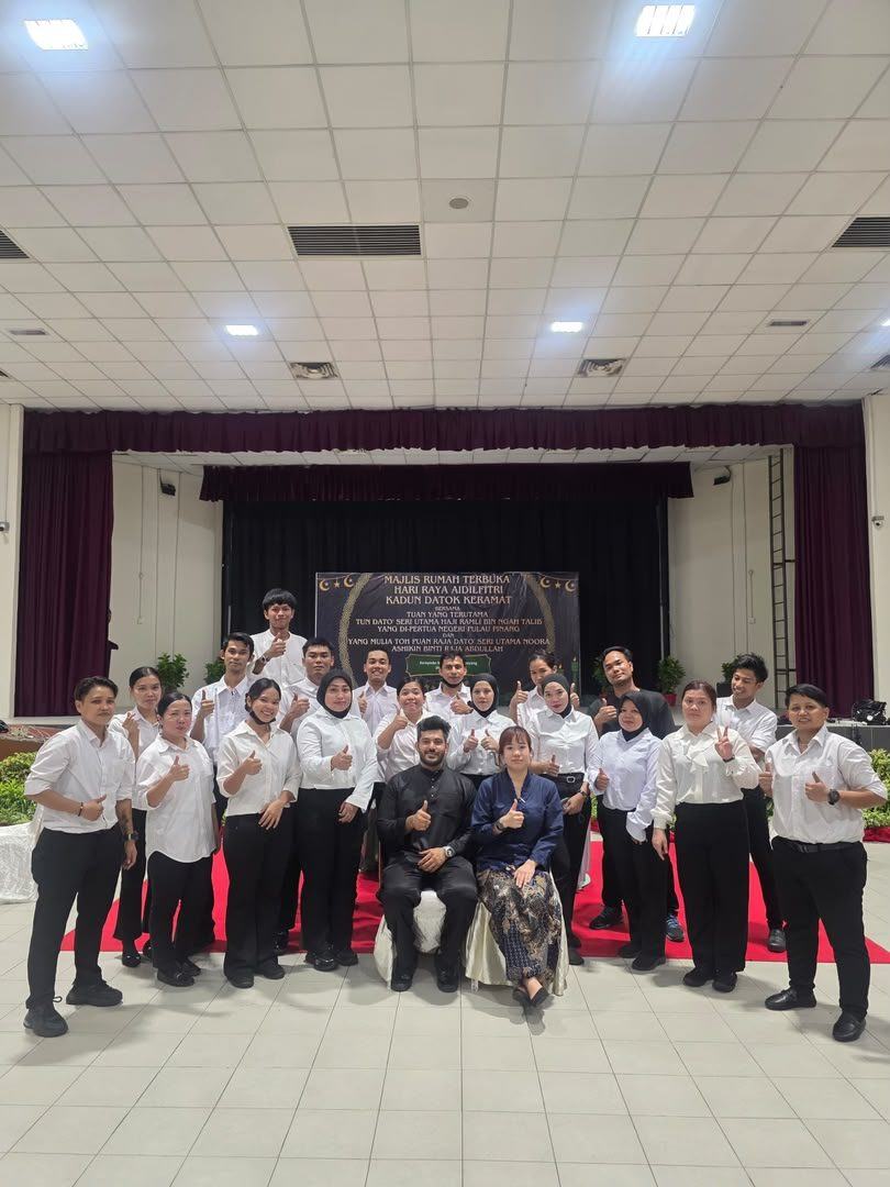 Hari Raya open house team photo on a red carpet